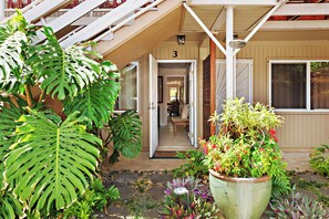 A hotel entrance with a staircase, a large potted plant, and a door marked with the number 3. - Steps to Maui's Charley Young Beach Condo Apt 3 (Kihei)