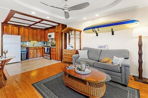 A compact living space with a kitchenette, a dining area, and a seating area with a sofa and a coffee table. - Steps to Maui's Charley Young Beach Condo Apt 5 (Kihei)