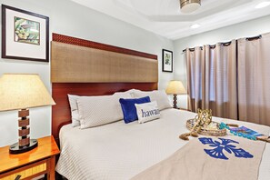 Quarto de hotel com uma cama, duas luminárias de cabeceira, cabeceira, um quadro na parede e uma janela com cortinas.