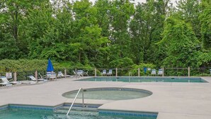 A swimming pool with multiple lanes, surrounded by lounge chairs and umbrellas, set against a backdrop of dense trees. - Mountain Views & Hot Tub | 1 Mi to Ober (Gatlinburg)