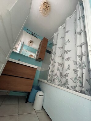 A compact bathroom with a sink, mirror, and a shower curtain with butterfly patterns. - ☀️ Getaway with a sea view • Swimming Pools • Wild Coast (Les Sables-d'Olonne)