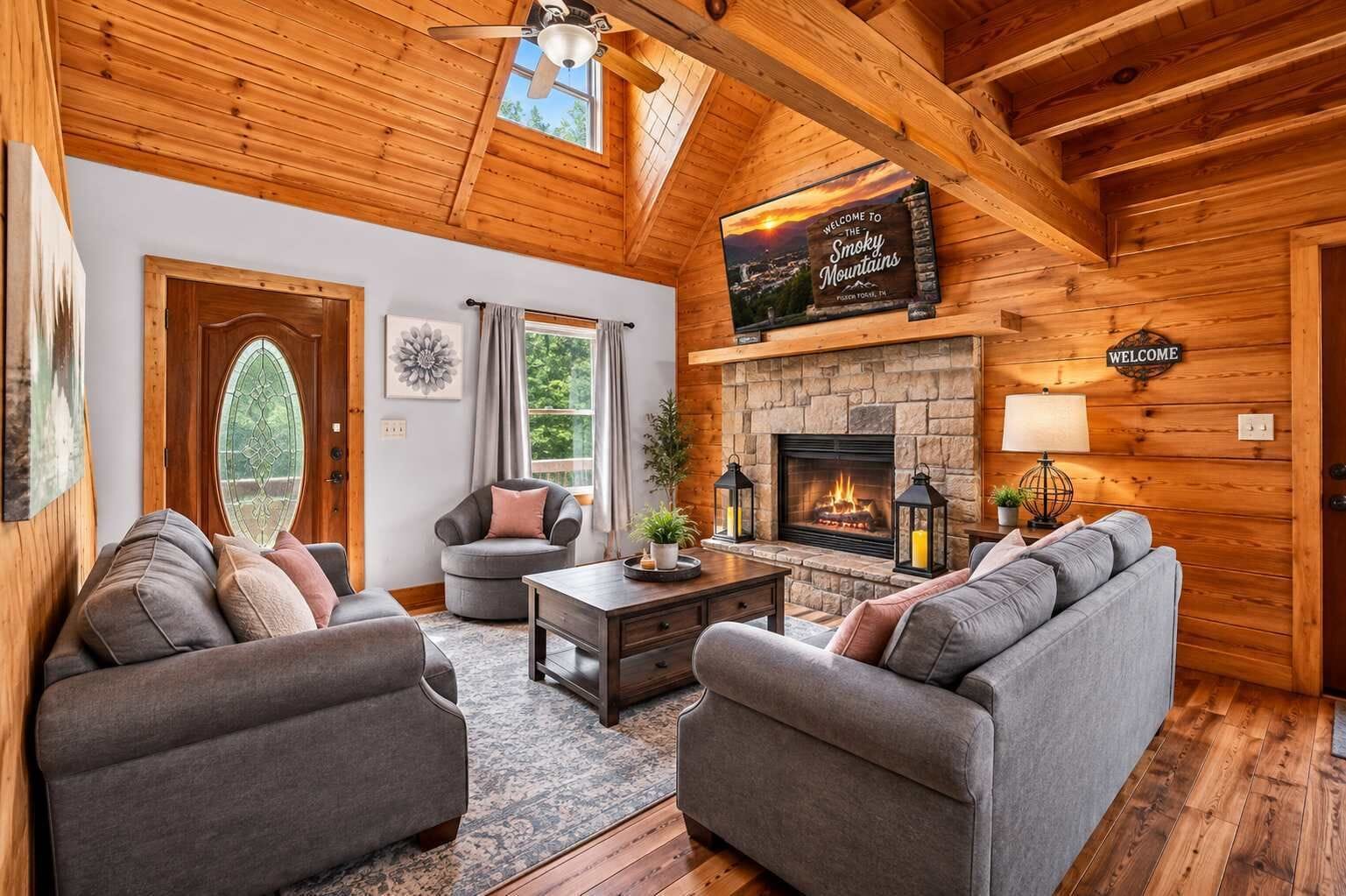 A cozy log cabin interior with a fireplace, two sofas, a round chair, and a wooden ceiling.