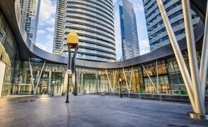 Un edificio moderno con fachada de vidrio curva, rodeado de edificios de gran altura.