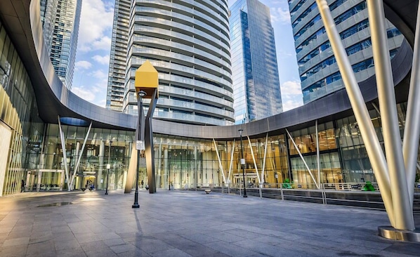 Un edificio moderno con fachada de vidrio curva, rodeado de edificios de gran altura.