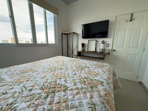 A bedroom with a bed, a TV mounted on the wall, a door, and a window. - Entire Place: Residence in San Miguel, El Salvador (San Miguel)