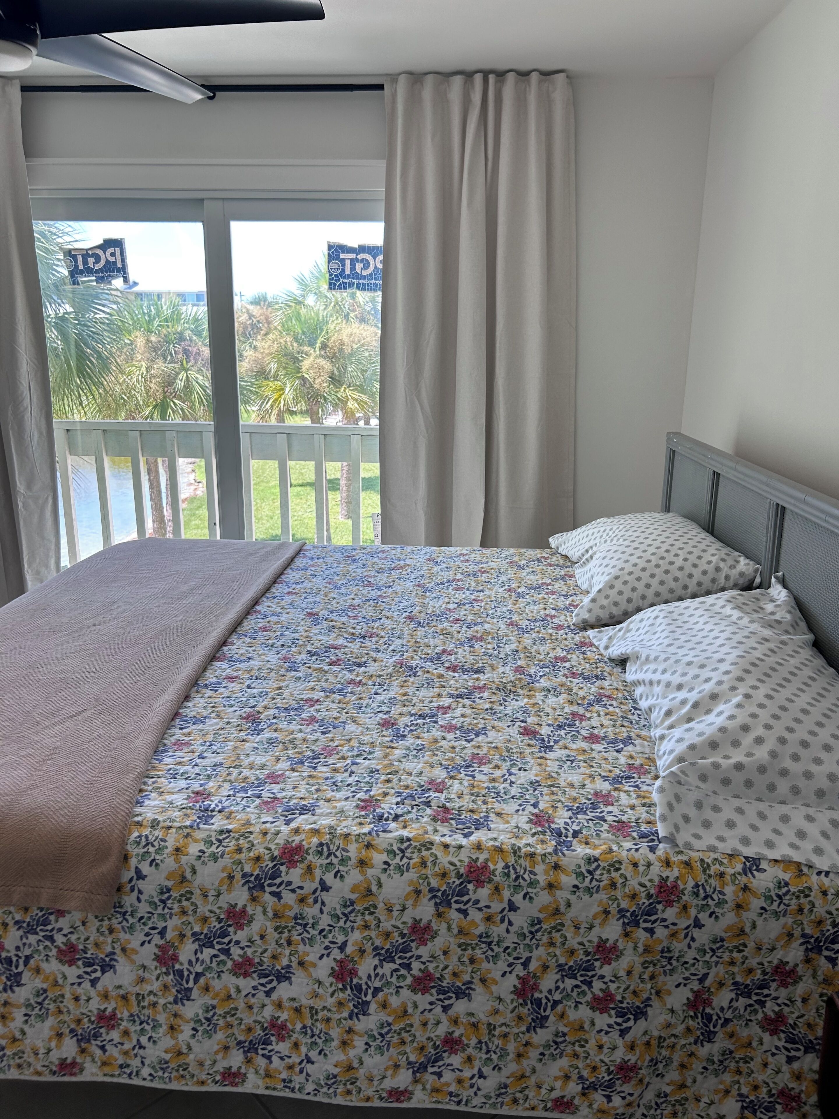Une chambre à coucher avec un lit, des rideaux et une vue sur un balcon.