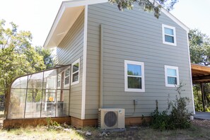 A two-story house with a large glass conservatory attached to the front. - Hill County Tiny Home on 5 Acres - near wedding venues (Austin)