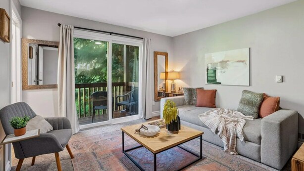 A living room with a sofa, armchair, coffee table, and a view through a sliding glass door to an outdoor deck. - Meadowview Retreat – 3BR/3BA, Hot Tub, Ski Shuttle, East Vail (Vail)