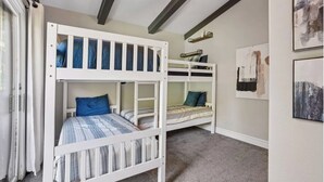 A room with bunk beds, a window with curtains, and artwork on the walls. - Meadowview Retreat – 3BR/3BA, Hot Tub, Ski Shuttle, East Vail (Vail)