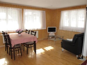 A room with a dining table, chairs, a TV, and a couch. - Helene Appartement/Fewo, Dusche, WC, 2 Schlafräume 3-Zimmerwohnung Parterre by Interhome (Adelboden)