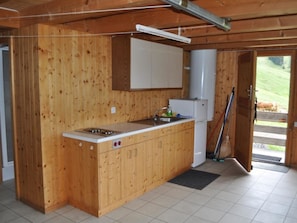 Eine Holz-Küche mit eingebautem Herd, Schränken und einem Spülbecken.