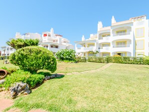 Ein Hotel mit mehreren weißen Gebäuden, einem gepflegten Rasen und blauem Himmel.