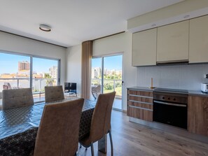 Eine moderne Wohnung mit Balkon, Essbereich und Küche.