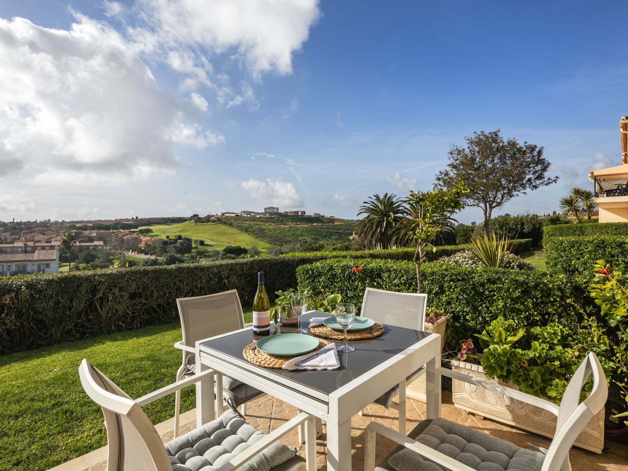 Un área de comedor al aire libre con una mesa para dos, con vistas a un paisaje pintoresco.