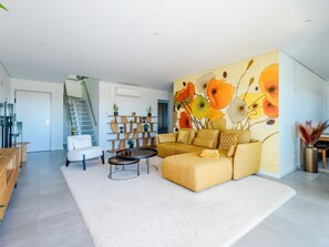A modern living room with a sofa, coffee table, and a staircase leading to another level. - Apartment  by Interhome (Tavira)