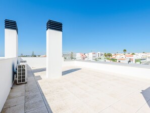 Eine Dachterrasse mit freiem Blick auf die Stadtlandschaft, mit modernen Gebäuden und einem ruhigen Himmel.