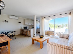 A modern apartment with a dining area, kitchen, and a balcony with a view. - Apartment  by Interhome (Vale do Lobo)