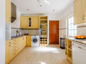 Eine Küche mit Waschmaschine, Backofen und Mikrowelle.
