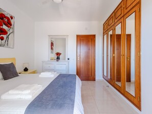 Ein Hotelzimmer mit Bett, Schminktisch, Spiegel und Kleiderschrank.