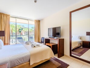 A hotel room with a bed, a desk, a television, and a large mirror. - Apartment  by Interhome (Guia)