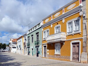 A row of colorful buildings with traditional architecture, including balconies and ornate window frames. - Apartment  by Interhome (Tavira)