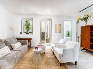 A modern living room with a sofa, armchairs, a coffee table, and a decorative plant. - Apartment  by Interhome (Tavira)