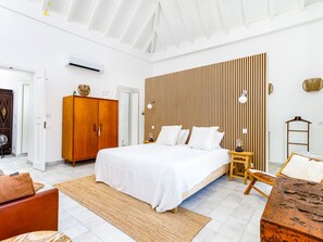 A spacious bedroom with a large bed, wooden panel wall, and a modern design. - TaviraBliss Terrace Apartment by Interhome (Tavira)