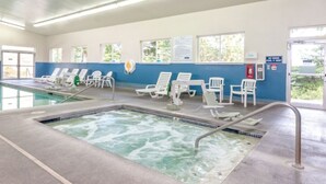Ein Poolbereich mit Liegestühlen und einem Whirlpool.