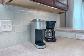 Et moderne køkken med en Keurig kaffemaskine og en Proctor Silex kande på disken.