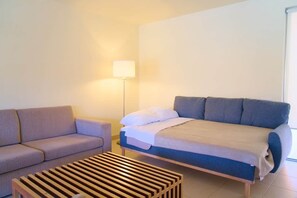 A bedroom with a bed, a sofa, and a wooden coffee table. - Villa Salgados private pool (Guia)