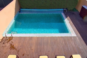 A rectangular pool with a wooden deck and a small grassy area behind it. - Villa Salgados private pool (Guia)