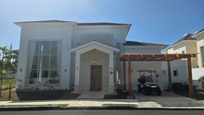A two-story house with a large window, a wooden door, and a covered porch. - Sophisticated 3 to 7 bedroom Royal Villas @ Lifestyle Holidays, Puerto Plata, DR (Cofresi)
