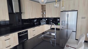 A modern kitchen with a built-in dishwasher, a stainless steel refrigerator, and a coffee maker. - Sophisticated 3 to 7 bedroom Royal Villas @ Lifestyle Holidays, Puerto Plata, DR (Cofresi)