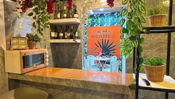 Una zona de bar con mostrador, taburetes y un cartel que dice 'HERMES PARIS'.