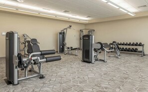 A hotel fitness center with various exercise equipment, including weight machines and dumbbells. - Phoenix Orange Beach 1202 (Orange Beach)