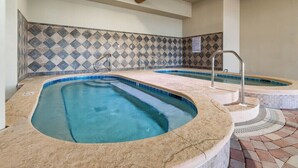 A spa area with two hot tubs and a tiled wall. - Phoenix Orange Beach 1202 (Orange Beach)