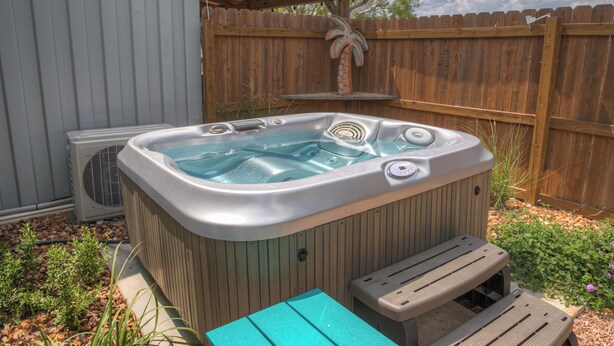A hot tub with a wooden deck and a wooden fence in the background. - Janis, Cozy 1-Bedroom Retreat in Gladheart, Sleeps 4, Hot Tub & Fire Pit (Fredericksburg)