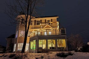 A two-story house with a balcony and string lights.