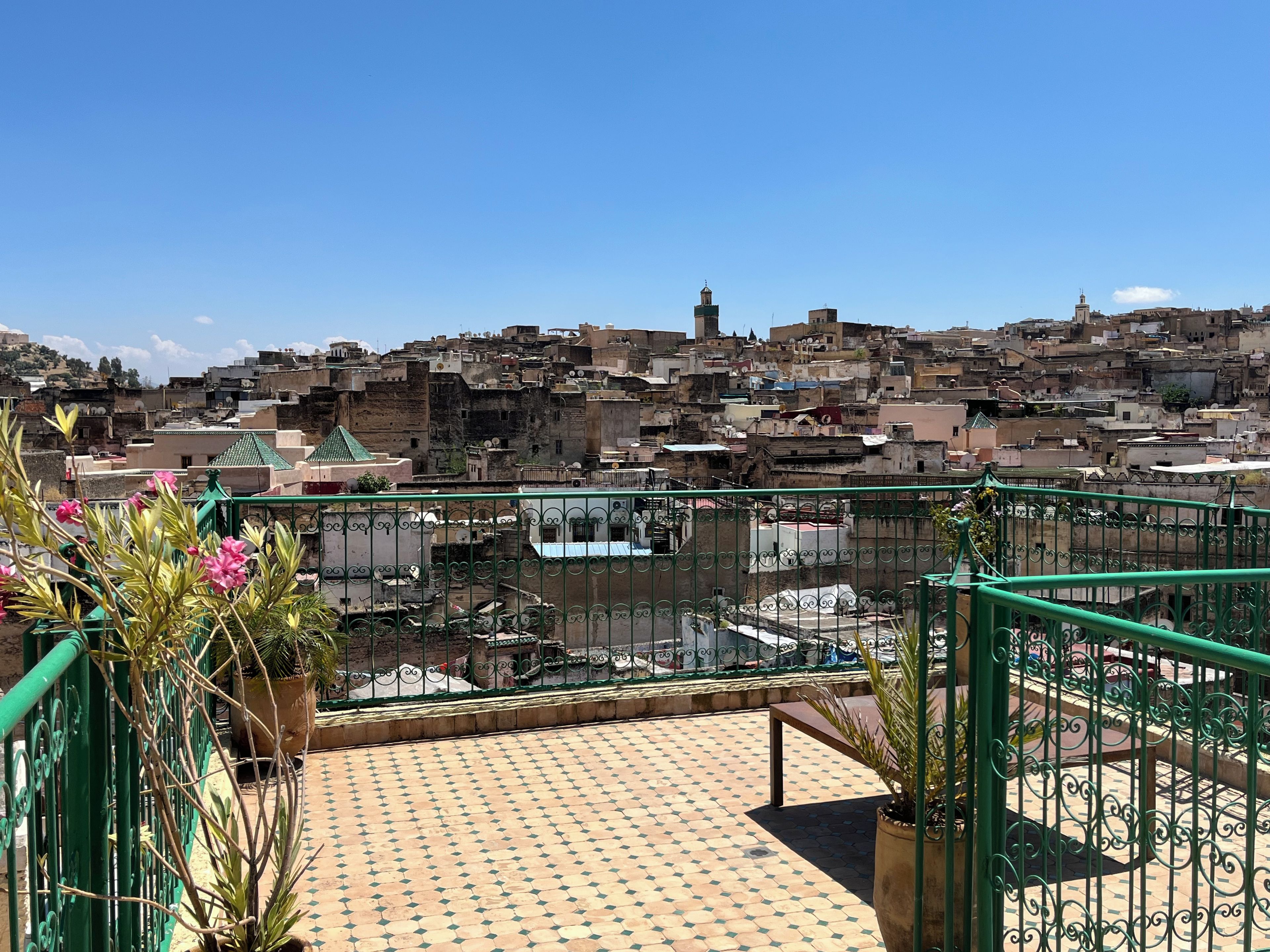 Une terrasse sur le toit offrant une vue sur un paysage urbain dense et animé.
