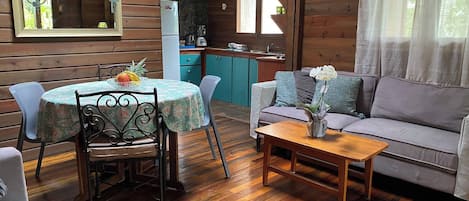 A cozy cabin interior with a dining area, a sofa, and a kitchen.