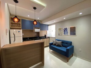 A modern kitchen with a wooden island, blue cabinets, and pendant lighting. - 302 - 2 Quartos Encatador (Belém)