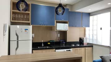 A modern kitchen with wooden cabinets, a built-in microwave, and a stainless steel sink.