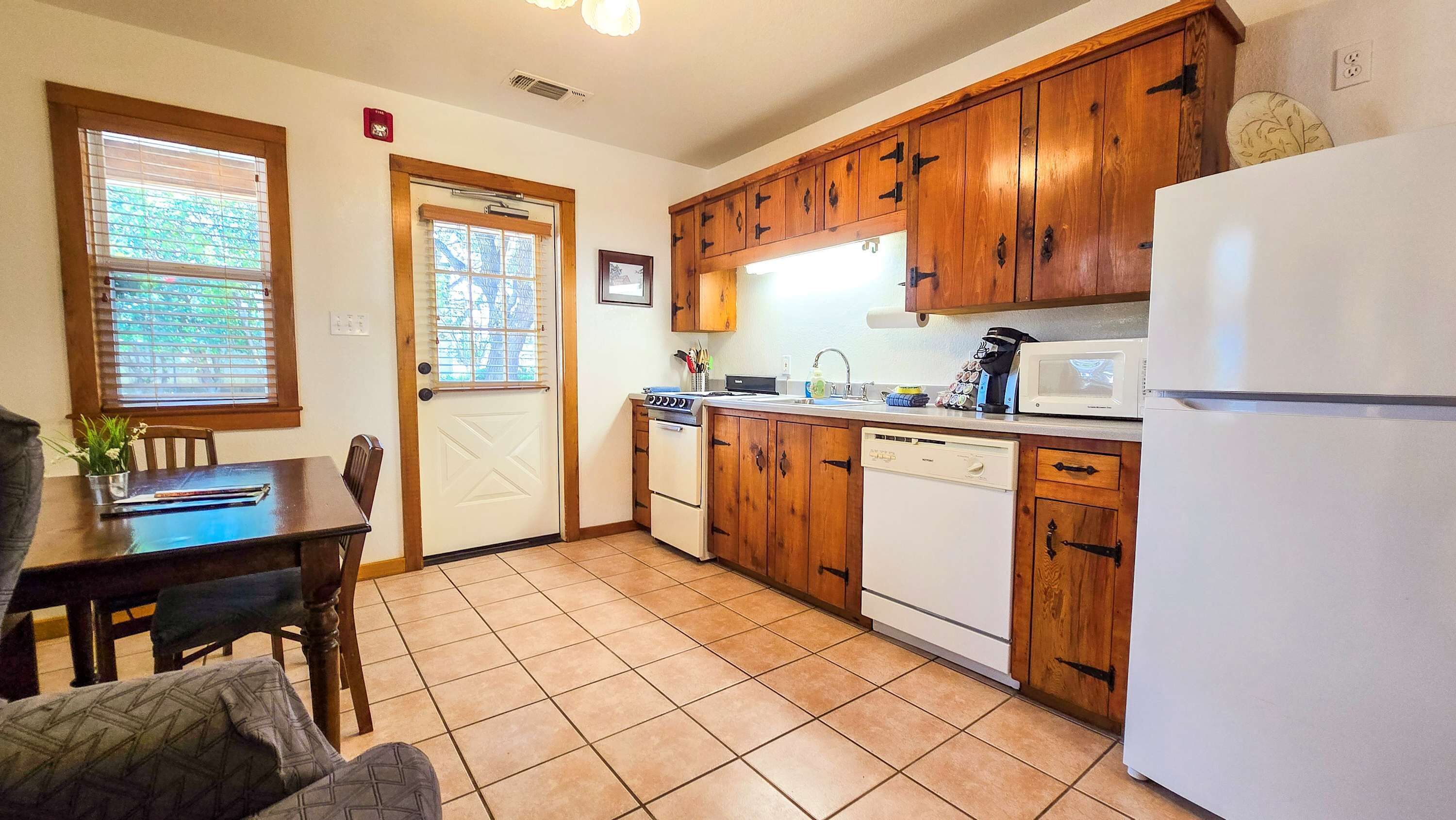 A kitchen with wooden cabinets, a white refrigerator, a stove, and a dishwasher.