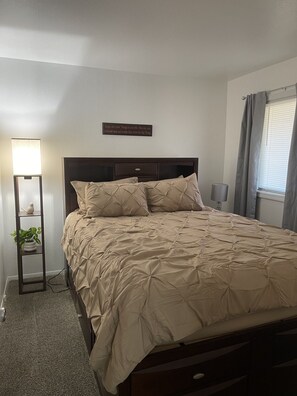 A bedroom with a bed, bedside lamps, a bedside plant, and a motivational quote on the wall. - Elegant & Cozy 2BR Apartment with Chugach Mountain Views #2 (Anchorage)