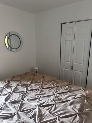 Una camera da letto con un letto, un armadio e uno specchio a parete.