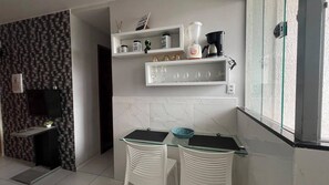 A modern kitchen with a marble backsplash, a glass-top table, and a built-in shelf with kitchenware. - 304 2 Qtos - Estilo e Confortável (Belém)