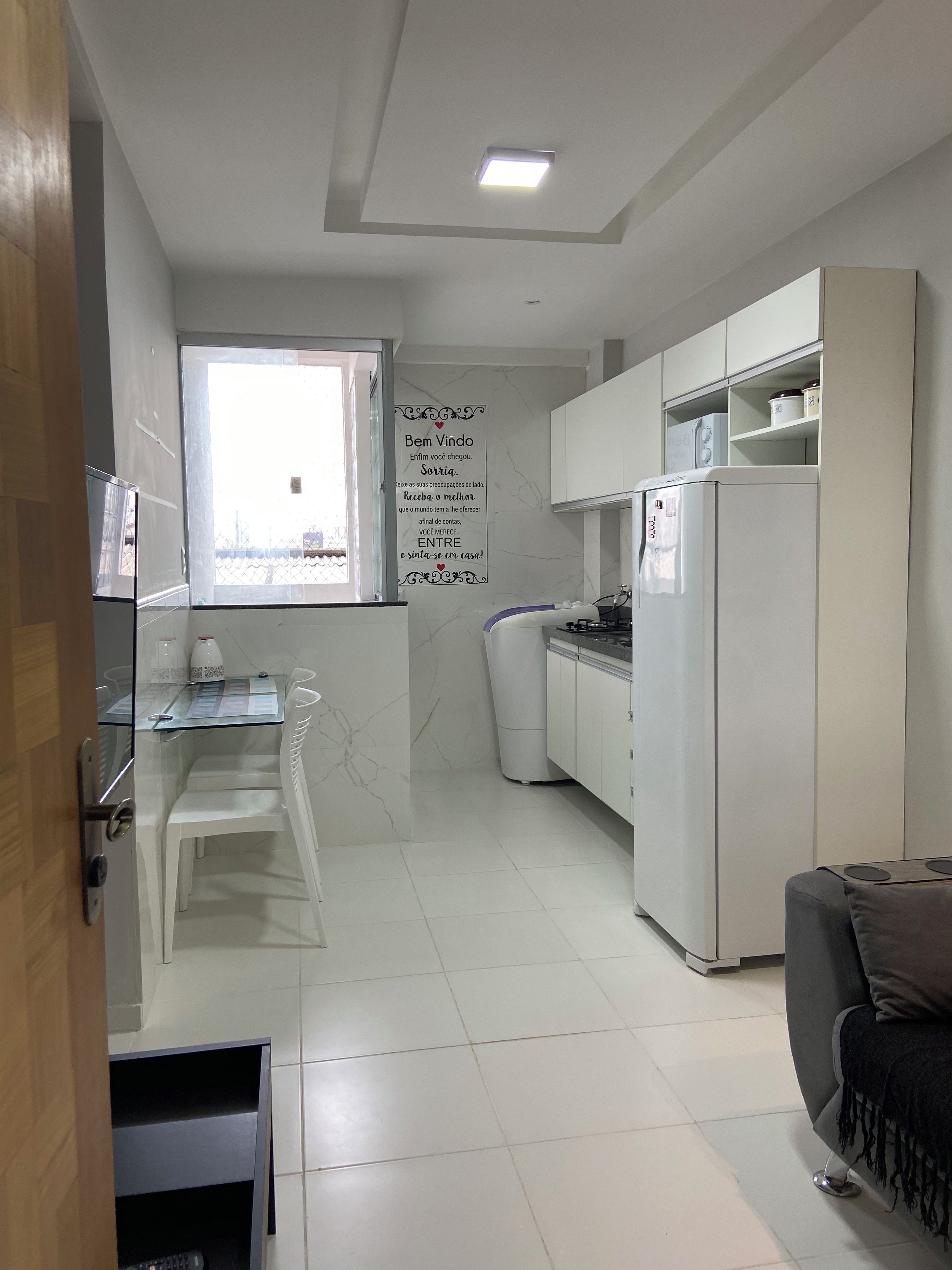 Una cocina moderna con comedor, refrigerador y ventana.