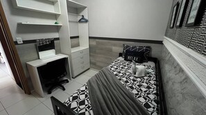 A bedroom with a bed, a desk, and a chair. - 304 2 Qtos - Estilo e Confortável (Belém)
