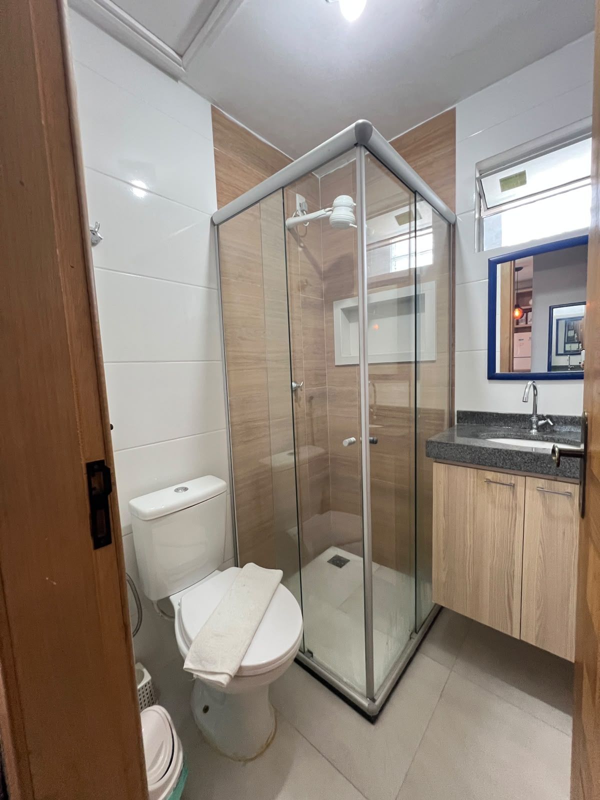 Une salle de bain avec une douche à parois de verre, des toilettes et un lavabo avec un plan de travail.