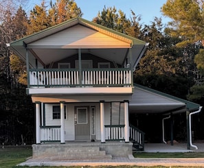 A two-story house with a balcony, a covered porch, and a garage.